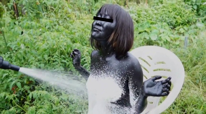 泡にまみれて黒い汚れを洗い流される際に見せる、自我を剥奪された標的の虚ろな表情 - The blank stare of the target losing her self-respect as foam and black filth mix on her skin.